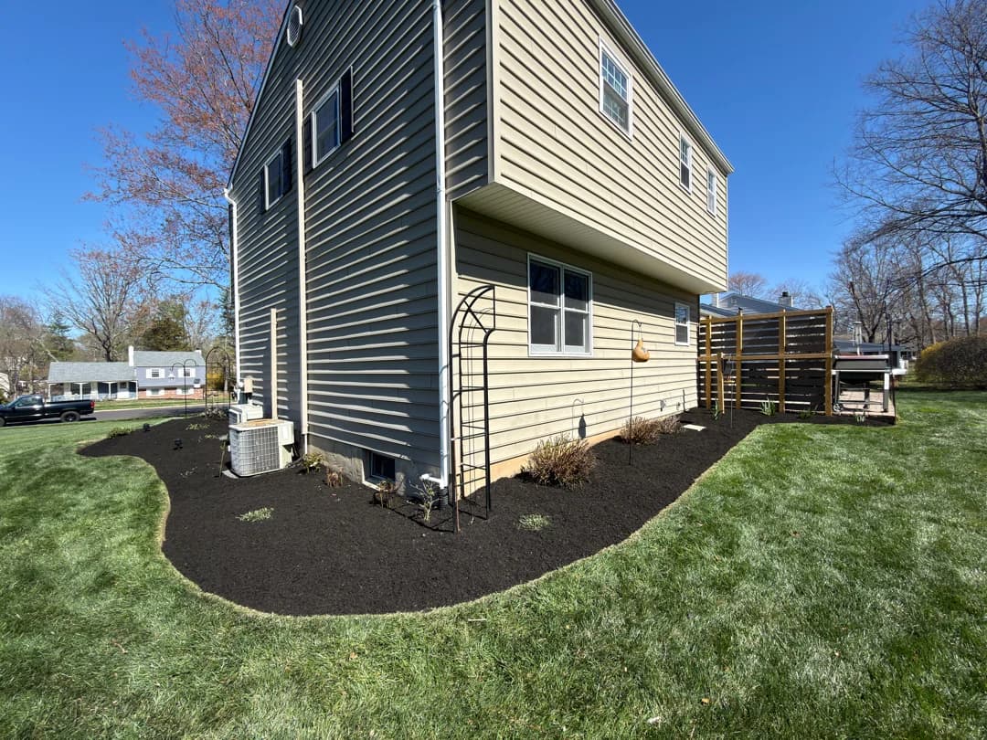 Foundation bed wrapping the side of a Montgomery County home with a clean, sweeping mulched border.